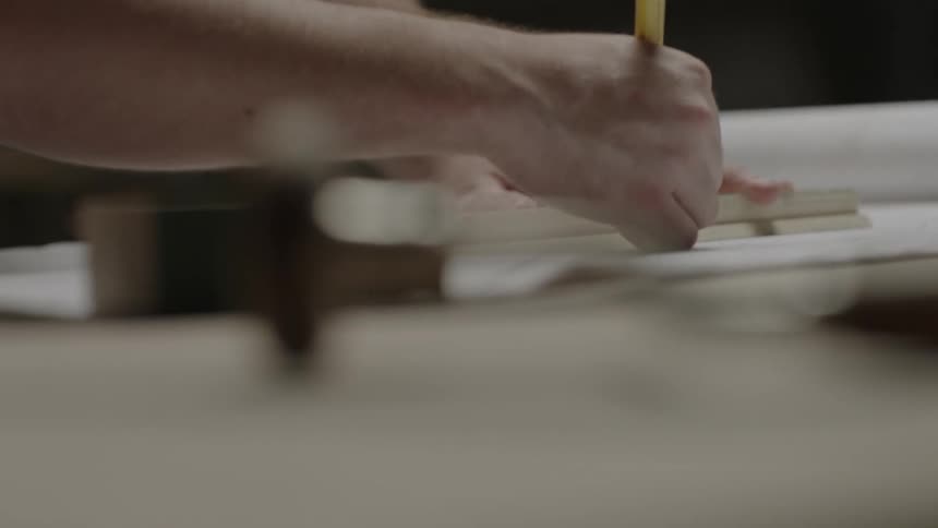 Person using a ruler to help draw up their plans