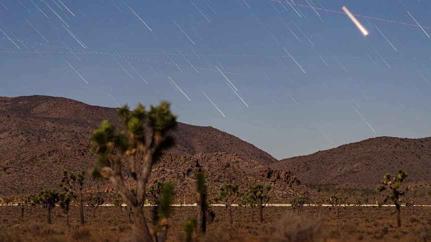 The sky above the mountain is full of shooting stars