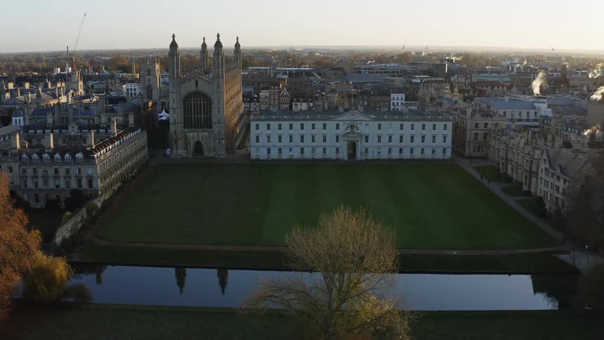 Kings College Chapel on a calm day with a river and field infront