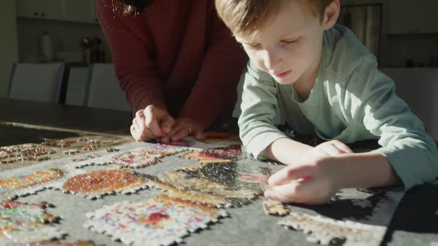 A mother and son put a puzzle together