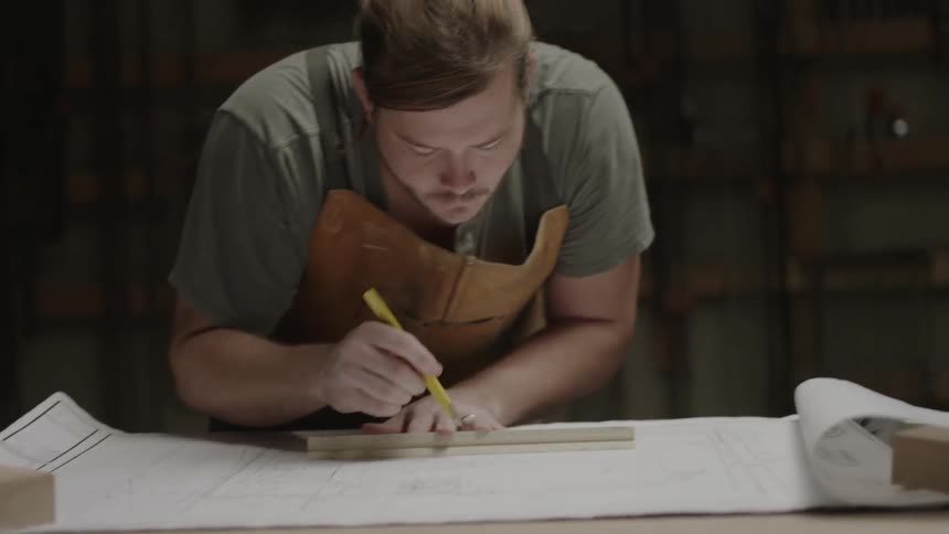 A man sketches on a work desk