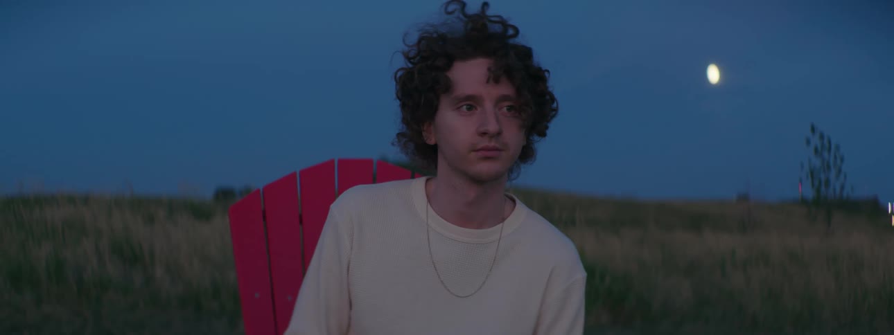 A man is sitting on a chair outside