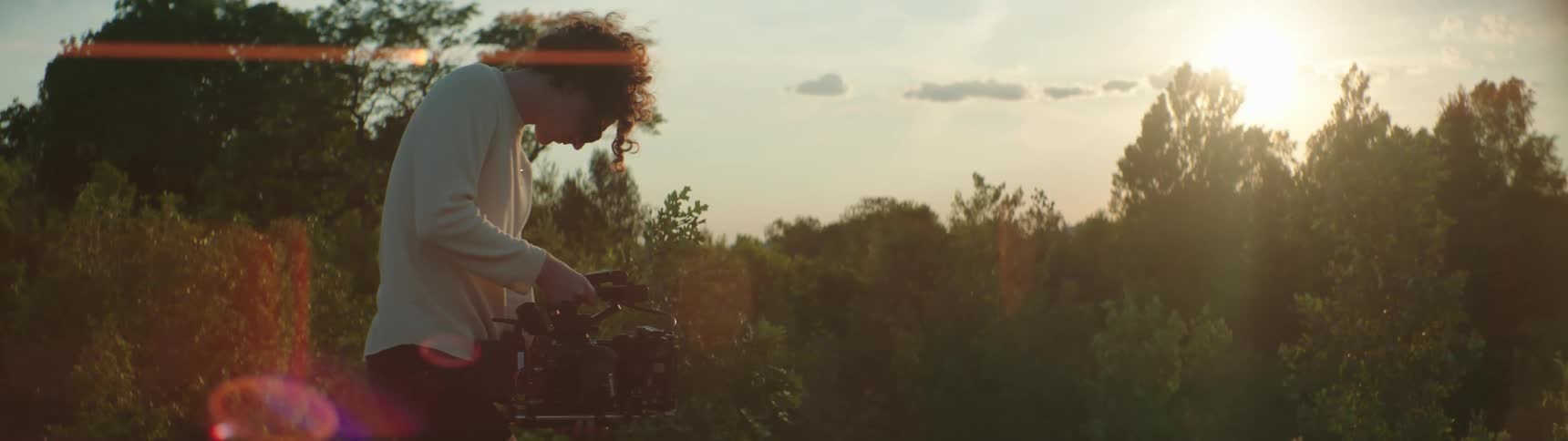 A man records video with a professonal camera in the woods