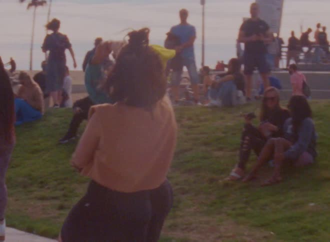 Women spin each other around as they dance and roller skate in front of a crowd