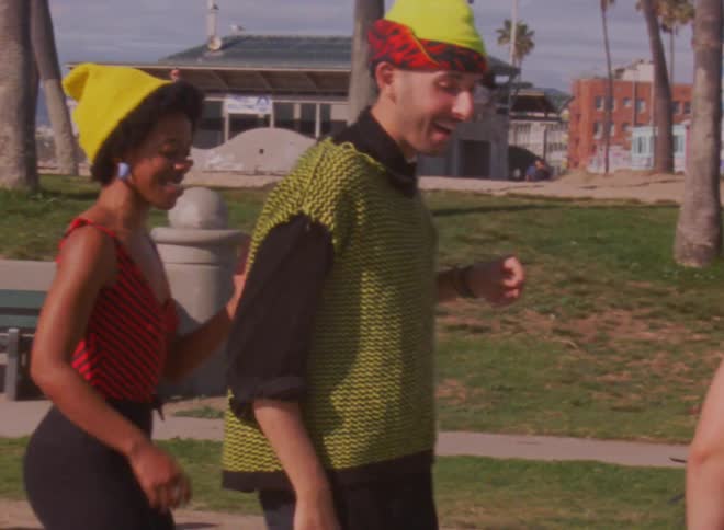 A group of people dance on roller skates in a park