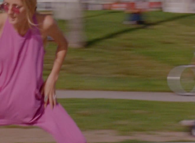 A woman spins and dances while skating in a park