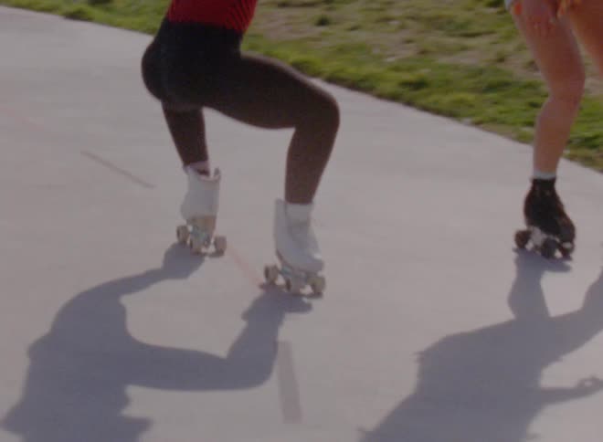 Two women are roller skating outside