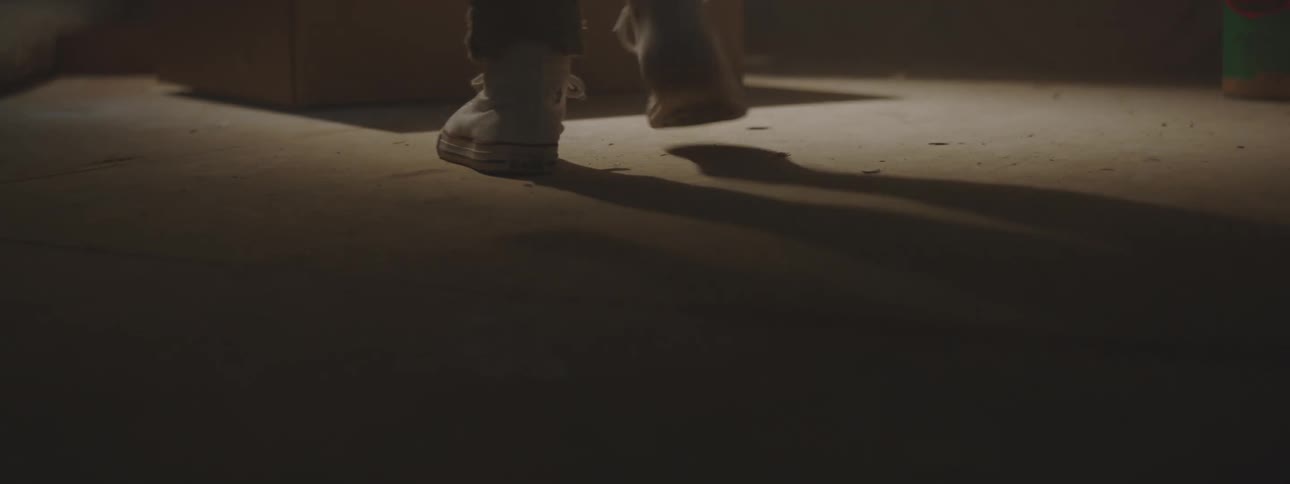 Person walks through dark room and sets flashlight on floor