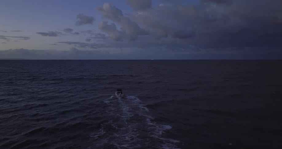 A speedboat sails further from land