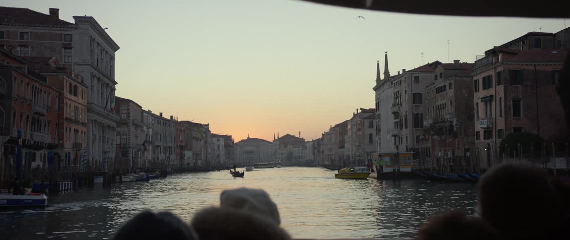 Romantic POV from a boat floating down the Grand Canal in Venice, Italy at sunset
