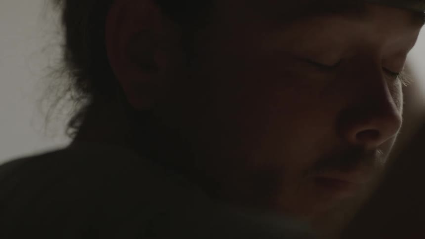 A man looks tired as he blinks slowly
