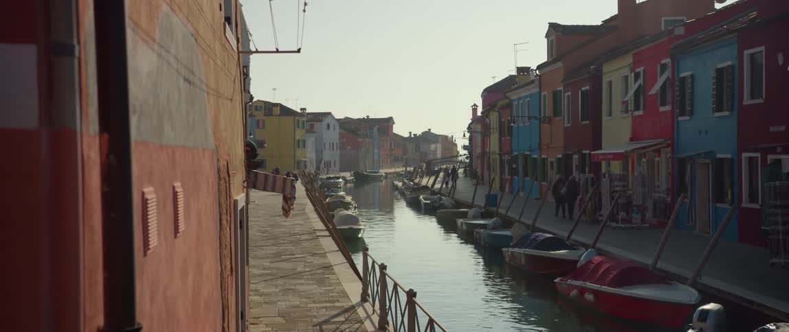 A canal lined with boats and colorful homes on Isola di Burano, Venice, Italy