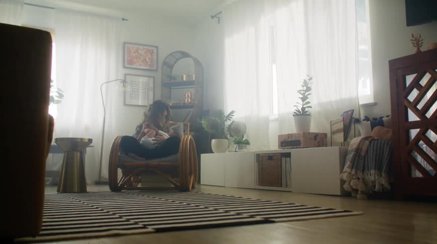 A woman holds her baby at home and talks to him