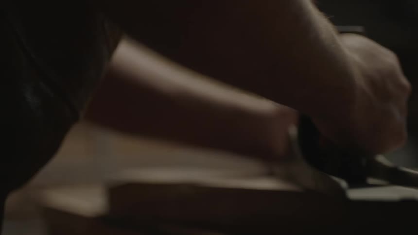 Man using a sander on a piece of wood