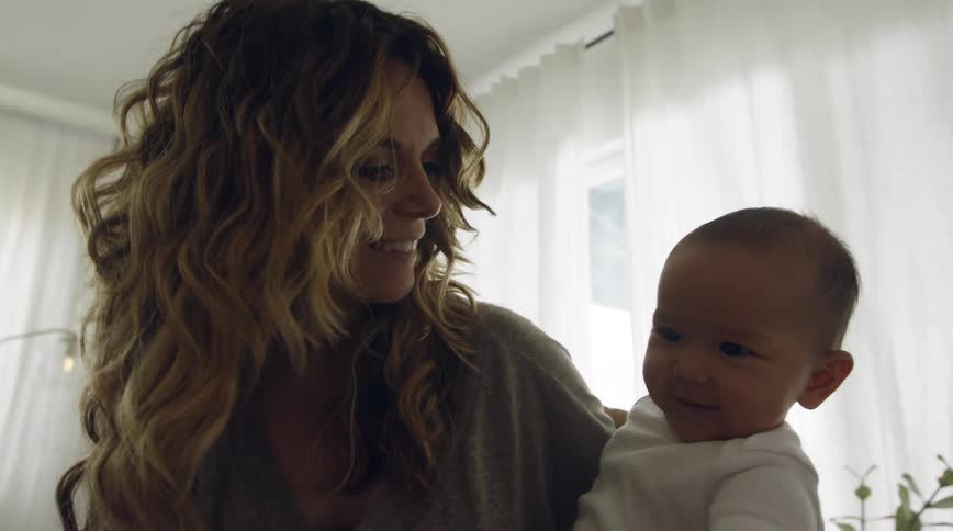 Mother plays with child tilting them toward the floor then back up
