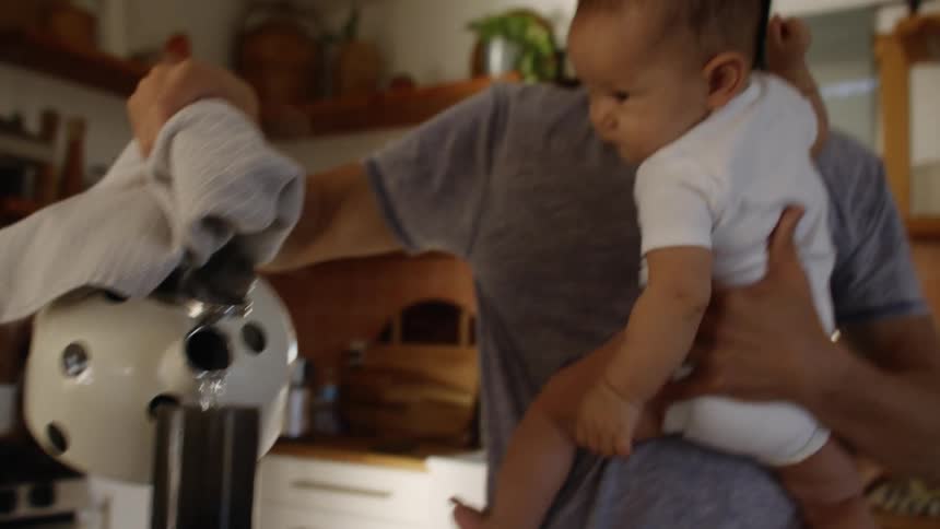 A father and baby working in a kitchen