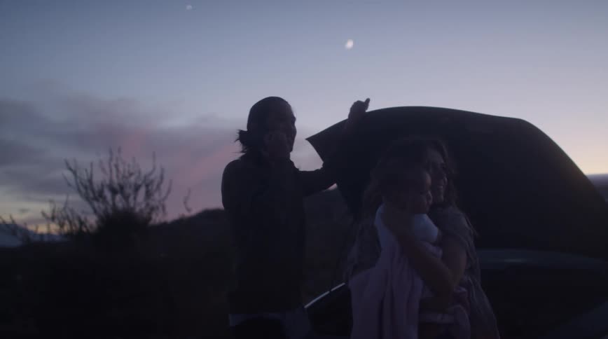 A family are standing outside of their broken down car