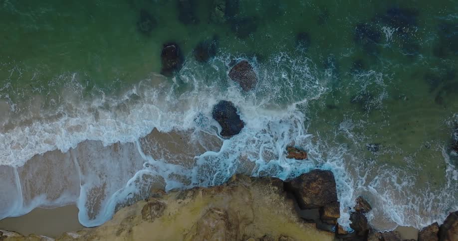 An aerial view of waves crashing in to the shore