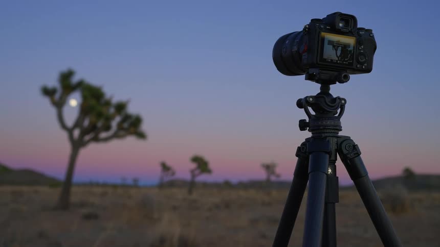 A camera is on a tripod in the desert