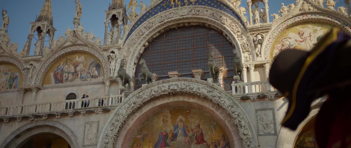 Panning down view of the Great Archway of Saint Marks Basilica, including the winged lion and 4 horses of Saint Mark proudly displayed above