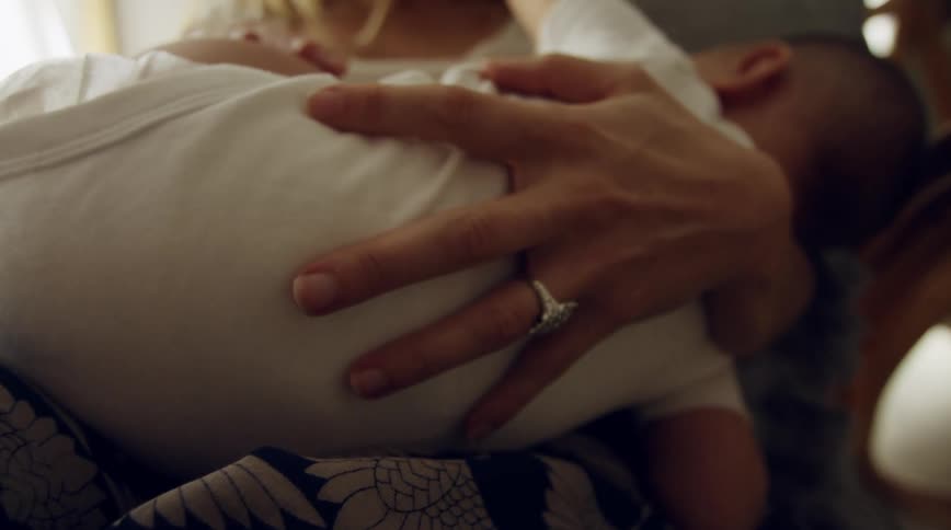 Mom sitting holding her baby to her breast