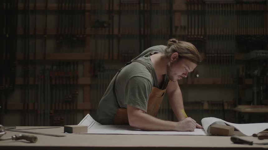 Man making a drawing of his plans in a workshop