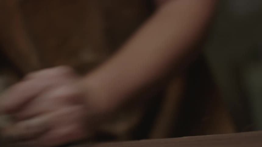 A man shaves a wooden block