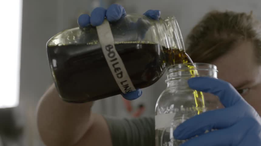 A man pours boiled linseed into a jar