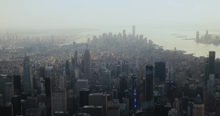 Dense city occupies area bordering water on foggy day