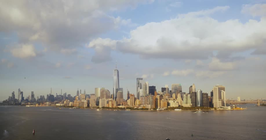 Boats floating in a harbor with skyscrapers in the distance in the daytime