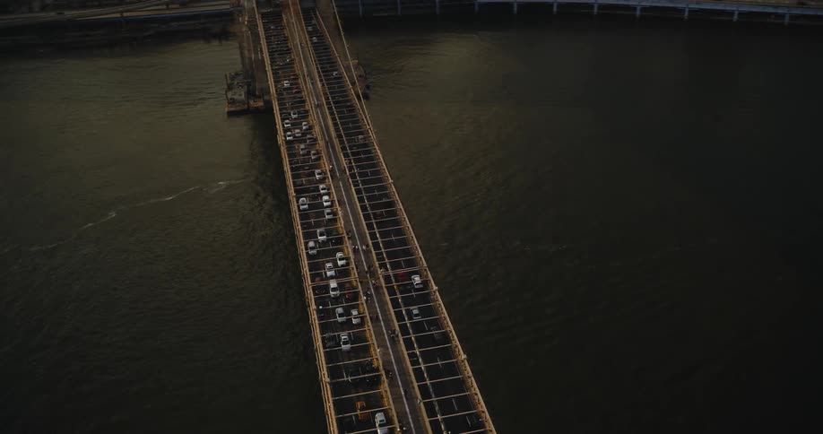 A large bridge spanning a waterway in a metropolis during the day