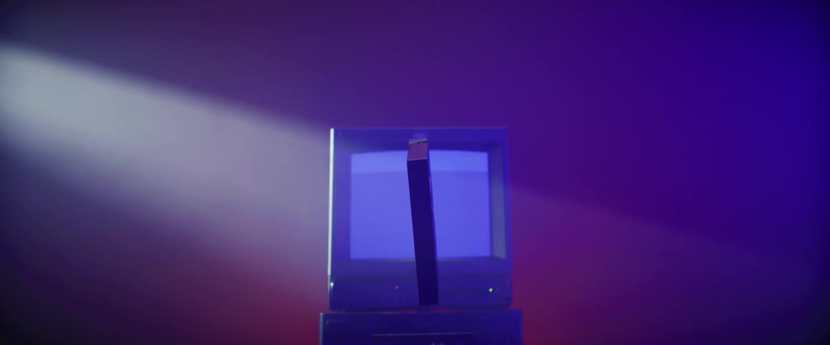 Vcr tape spins around in front of a vintage television with static on the screen