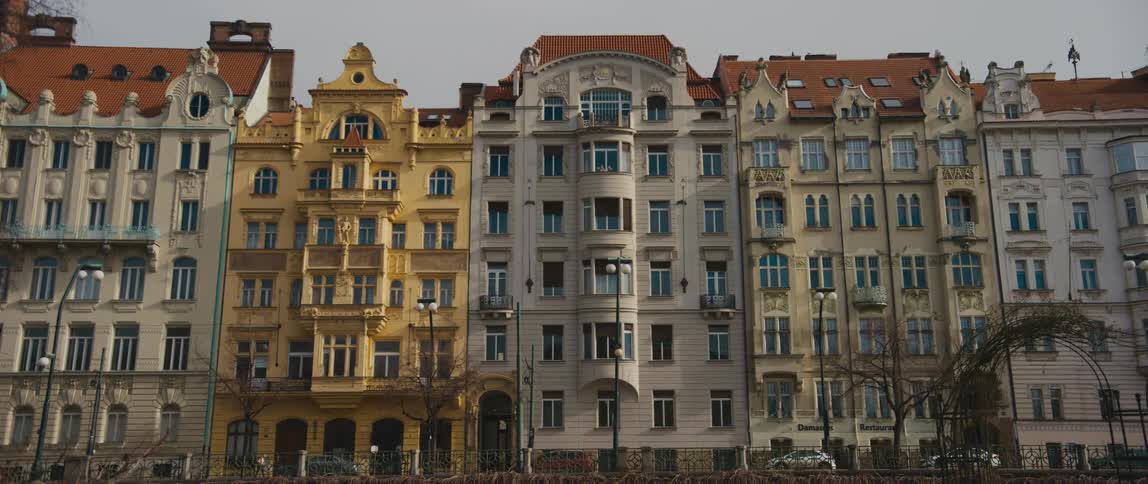 Several tall buildings stand side by side in a scenic european city