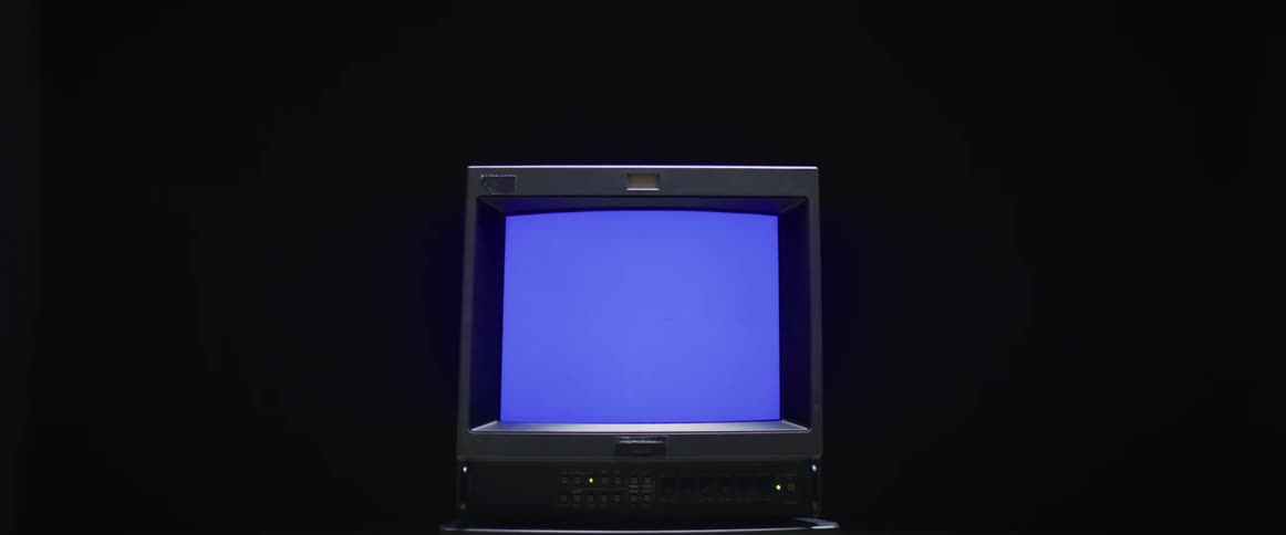 A vintage computer with display playing blue static against a black background