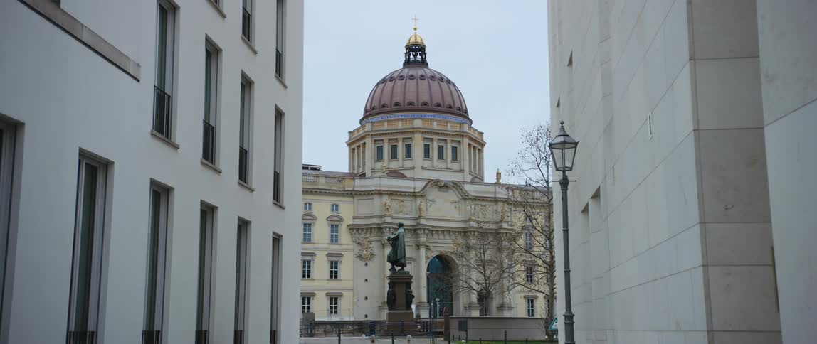 View through buildings of the entrance and dome of the Humboldt Forum museum housed within the reconstructed Berlin Royal Palace