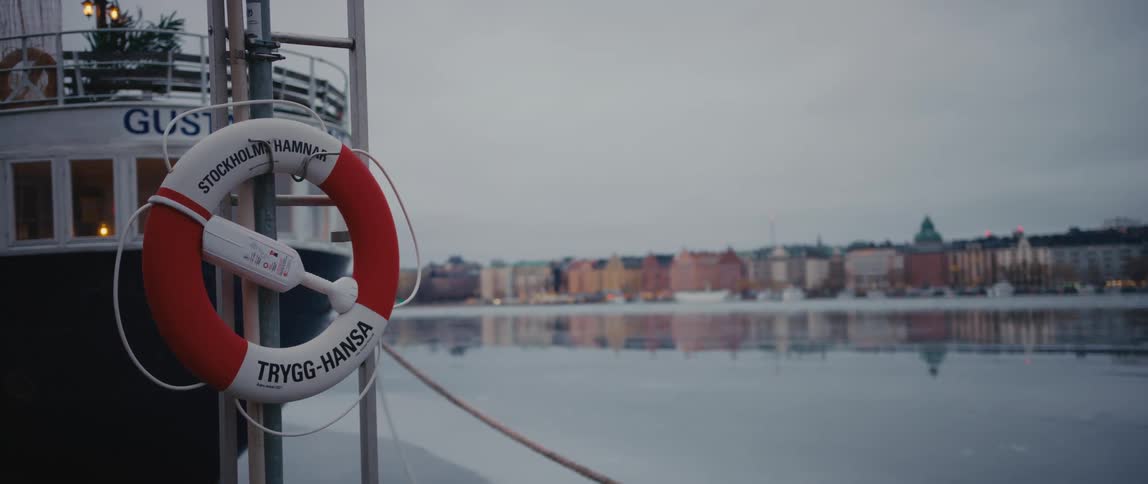 Red and white life preserver on a boat in the river near the city