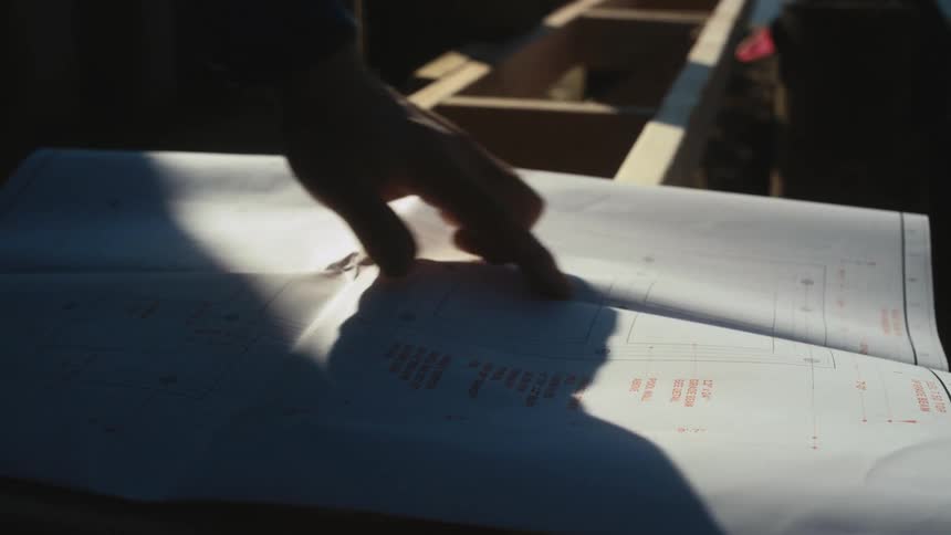 A man reads blueprints at a construction site