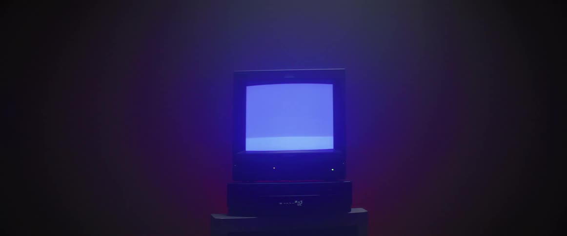 Scrolling static on a vintage television that is sitting on top of a receiver with the number two on its display