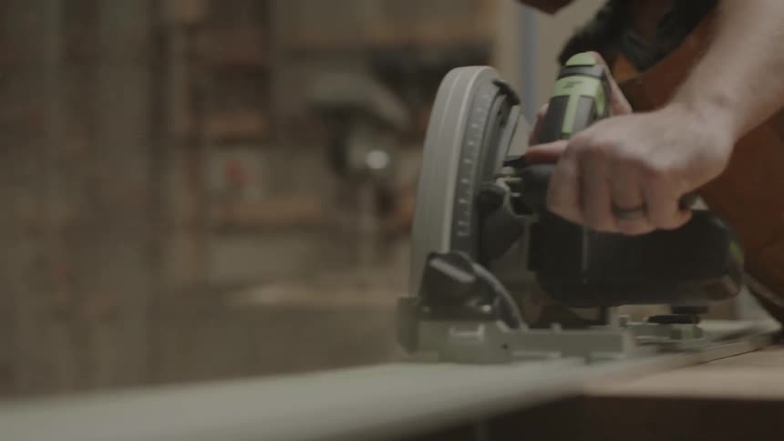 Man working with a power saw in his shop