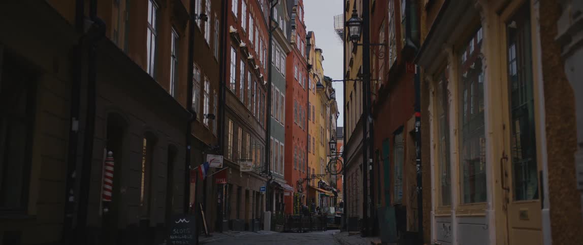 An alley through city buildings in the daytime