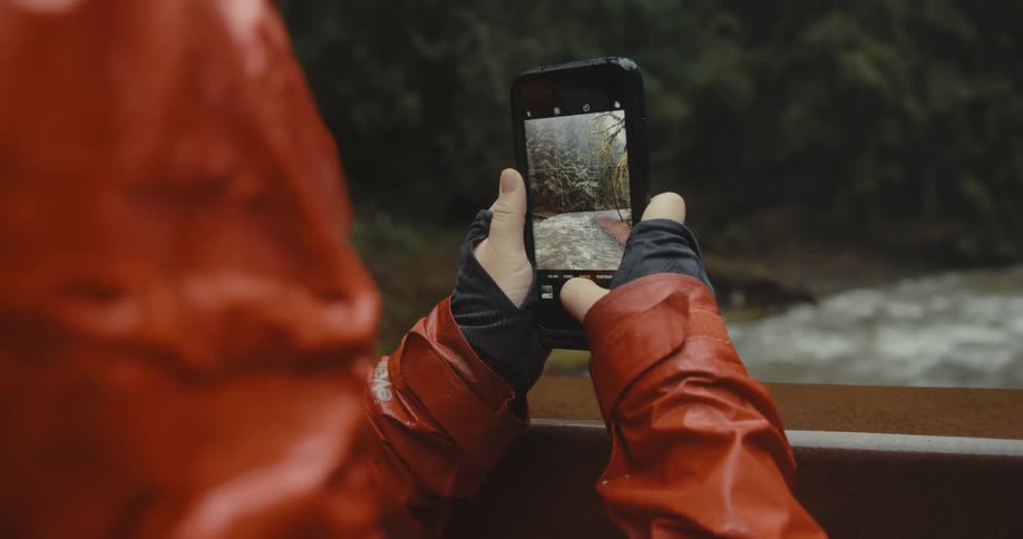 A person using a phone near a river