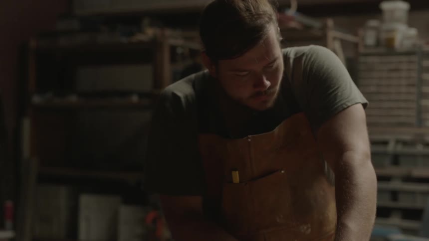 Man working in his shop wearing a protective apron