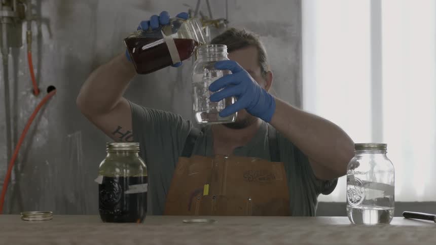 Man pouring one liquid into another from a jar