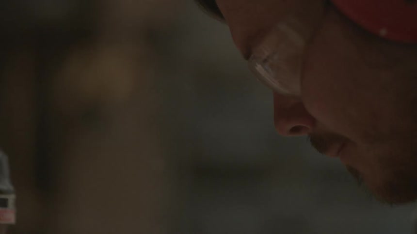 Close-up of a man wearing safety glasses and ear protection