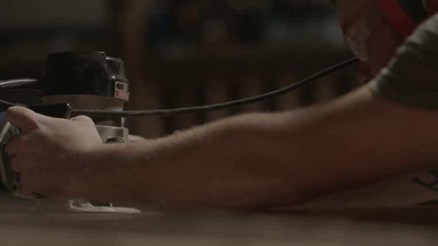 Man using an electric sander machine on wood
