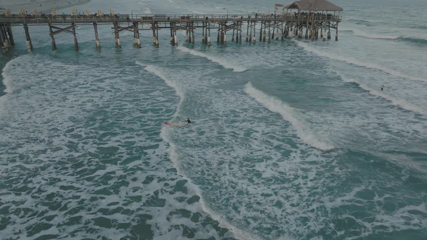A person surfs in to the shore