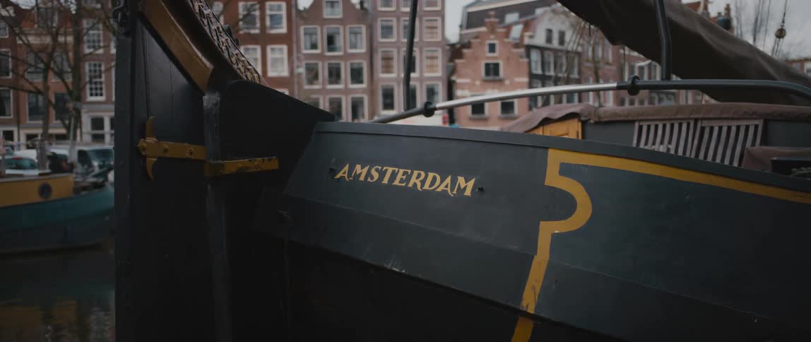 Houseboat with a sail on a canal in Amsterdam