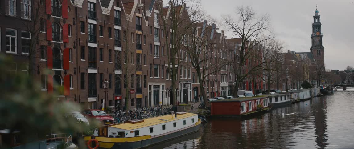 View of canal in Amsterdam with boats on a cloudy day
