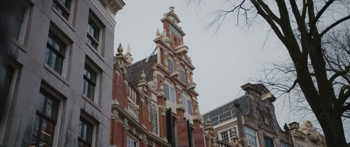 Bartolotti House in Amsterdam, with it's elaborate exterior and impressive architecture, stands tall under a gray sky.