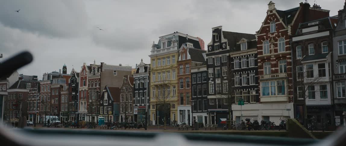 A row of buildings along a canal in Amsterdam on a cloudy day